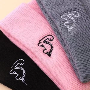 Three kids knit beanies in black, pink, and grey with cute dinosaur embroidery