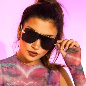 Detailansicht der großen quadratischen Sonnenbrille mit schwarzen Gläsern und Goldsteg