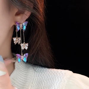 Detail of long butterfly tassel earrings with purple and blue gradient rhinestones