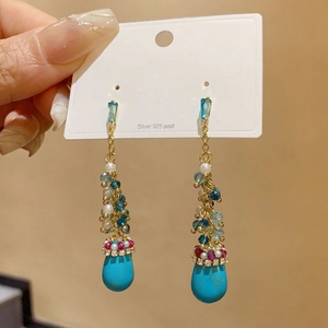 Detailed shot of long ethnic earrings with turquoise drops and 925 silver needles