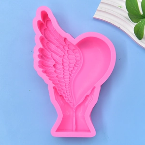 Pink silicone mold featuring hands holding heart with wings for DIY candle or soap making