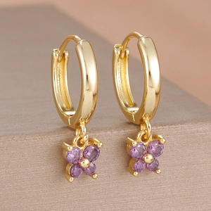 Détail de créoles plaquées or 18k avec pendentifs fleurs en pierres violettes