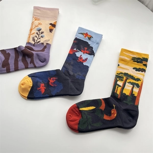 Close-up of cotton mid-calf socks featuring unique bird and tree graffiti art patterns