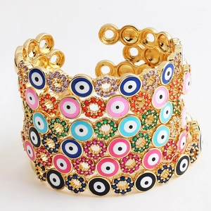 Detail of gold-plated open bangles featuring colorful zircon and enamel evil eye charms