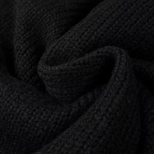 Vue détaillée de la texture du tissu en tricot noir sur le cardigan de style doux