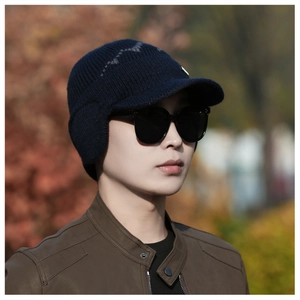 Detail of dark blue winter knit visor cap with ear protection for men on outdoor model