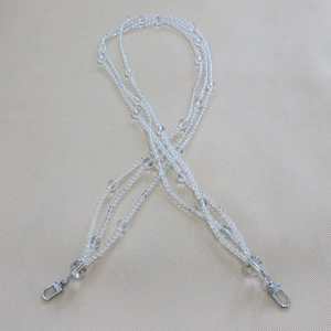 Macro shot of transparent beaded strap with silver metal lobster clasps on neutral surface