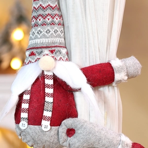 Detailaufnahme eines Weihnachtsgnom-Vorhanghalters mit grauer Strickmütze und rotem Körper