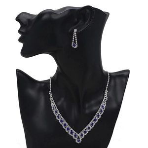 Close-up of silver bridal jewelry set with blue and clear rhinestones on a black mannequin