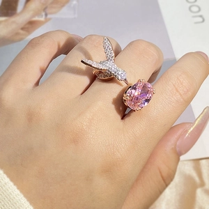 Detail of adjustable hummingbird ring with oval pink gemstone and rose gold plating