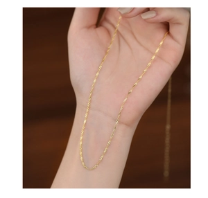 Macro shot of 18K gold water wave chain showing fine twisted texture in hand