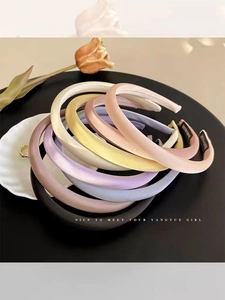 Detail of colorful satin padded headbands with handmade label on an elegant tray