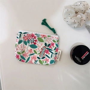 Floral cotton pouch with zipper and green tassel detail for makeup storage