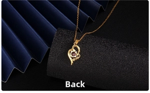 Detailed back view of heart pendant showing gold metal claw setting and purple stone
