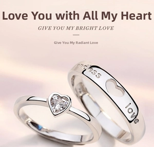 Close-up of heart-cut cubic zirconia and endless love engraving on couple rings