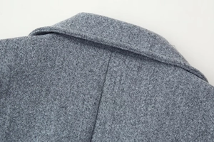 Macro detail of notch lapel collar on grey wool coat showing premium stitching and texture