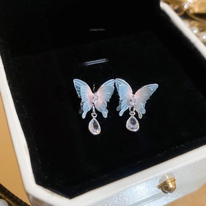 Détail macro de boucles d'oreilles papillon bleu avec zircons en forme de goutte d'eau