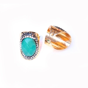 Detail of bohemian gold ring with turquoise stone, pavé crystals and hammered texture