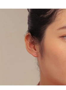 Minimalist bar earring in 14K gold plating with cubic zirconia worn by a model
