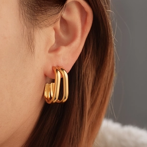 Minimalist gold-tone double U-shaped stainless steel earrings on a female model