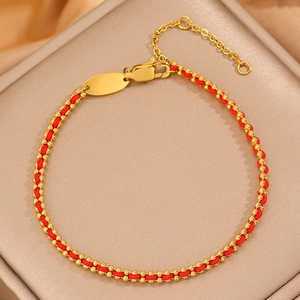 Red cord bracelet with gold beads and polished oval charm featuring adjustable lobster clasp
