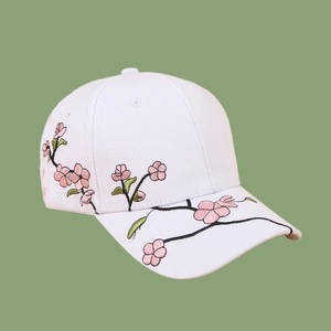 Close-up of pink cherry blossom embroidery on white cotton canvas baseball cap