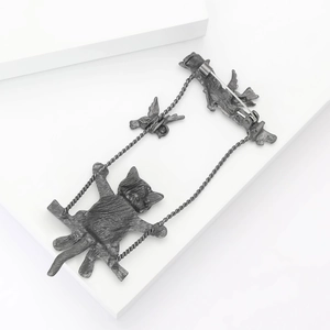 Close-up of vintage cat on swing brooch with bird detail and secure back pin