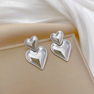 Minimalist silver titanium steel double heart earrings on elegant velvet base