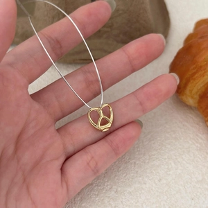 Modern two-tone pretzel heart necklace in gold and silver finish with fine chain