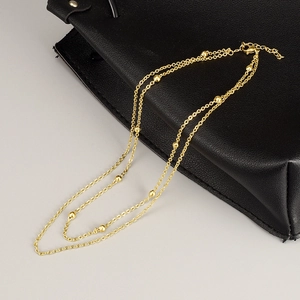 Double-layered gold titanium steel beaded necklace with adjustable lobster clasp on leather