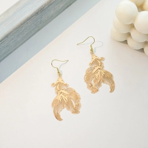 Close-up of golden hollow goldfish earrings with intricate Chinese style lacquer design
