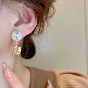 Detailed close-up of French vintage drop earring featuring a faux pearl and textured gold disc