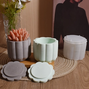 Moule en silicone et pots en plâtre cannelés gris et vert menthe sur socle en bois