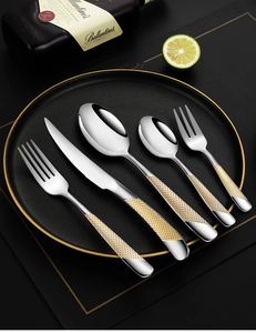 Detail of gold diamond texture handle on stainless steel cutlery set with mirror finish