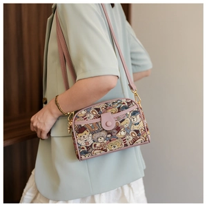 Detailed view of pink canvas bear crossbody bag worn with a stylish mint blazer