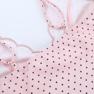 Detail of pink polka dot dress showing adjustable straps and wavy embroidered edges