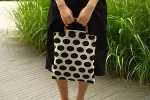 Detailed shot of retro polka dot canvas handbag with unique natural bamboo handles