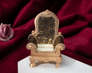Detail of vintage sofa-style jewelry box with bronze floral relief and cream satin padding