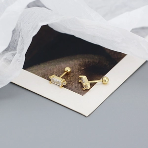 Macro detail of gold bar earrings with clear cubic zirconia and screw-back closure