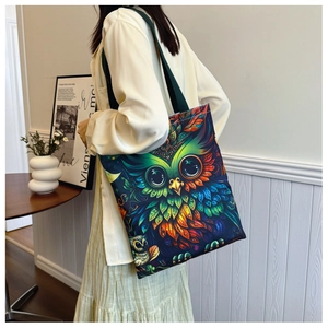 Artistic colorful owl print detail on high-capacity canvas tote bag worn by model