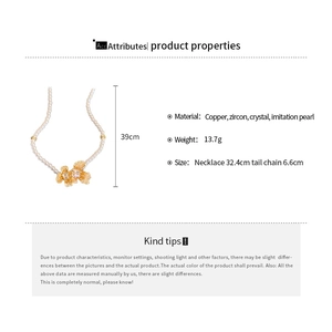 Detailed view of pearl necklace with gold plated floral pendants and zircon accents