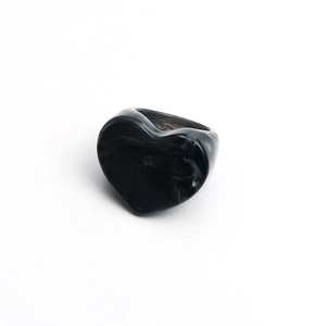 Close-up of heart-shaped resin rings with black and white marble texture on white background