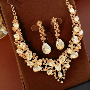 Detail shot of champagne gold jewelry set with teardrop crystals on a velvet stand