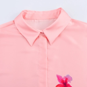 Gros plan détaillé du col de chemise en satin de soie rose et texture lisse à motif floral