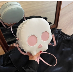 Macro shot of skull-shaped crossbody bag with pink heart nose and silver metal zippers