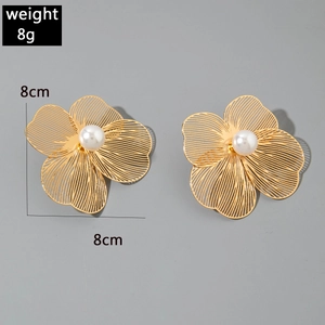 Détails de boucles d'oreilles fleur dorées avec perles blanches et pétales creux