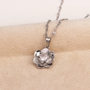 Close-up of a silver rose flower pendant necklace with a sparkling crystal center stone