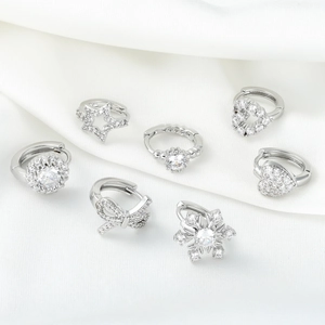 Set of seven silver-tone copper hoop earrings with white zircon on white silk background