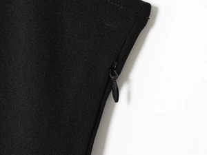 Detail shot of the hidden back zipper and fine knit fabric texture on this black dress