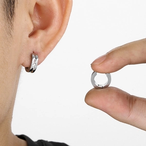 Close-up of minimalist silver stainless steel hoop earring with zircon inlay for men
